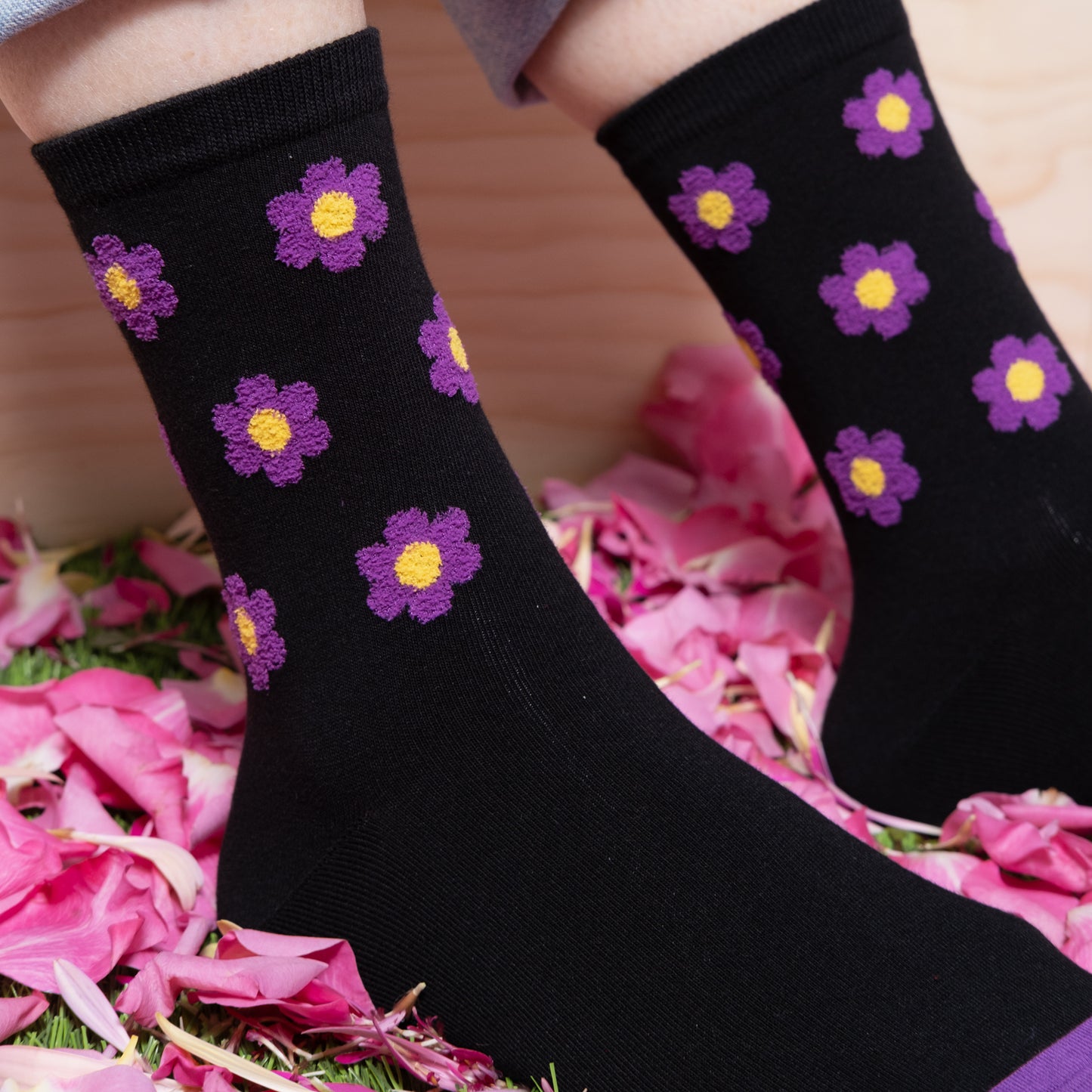 Close detail of woman wearing luxurious black ankle socks with textured purple floral dots pattern