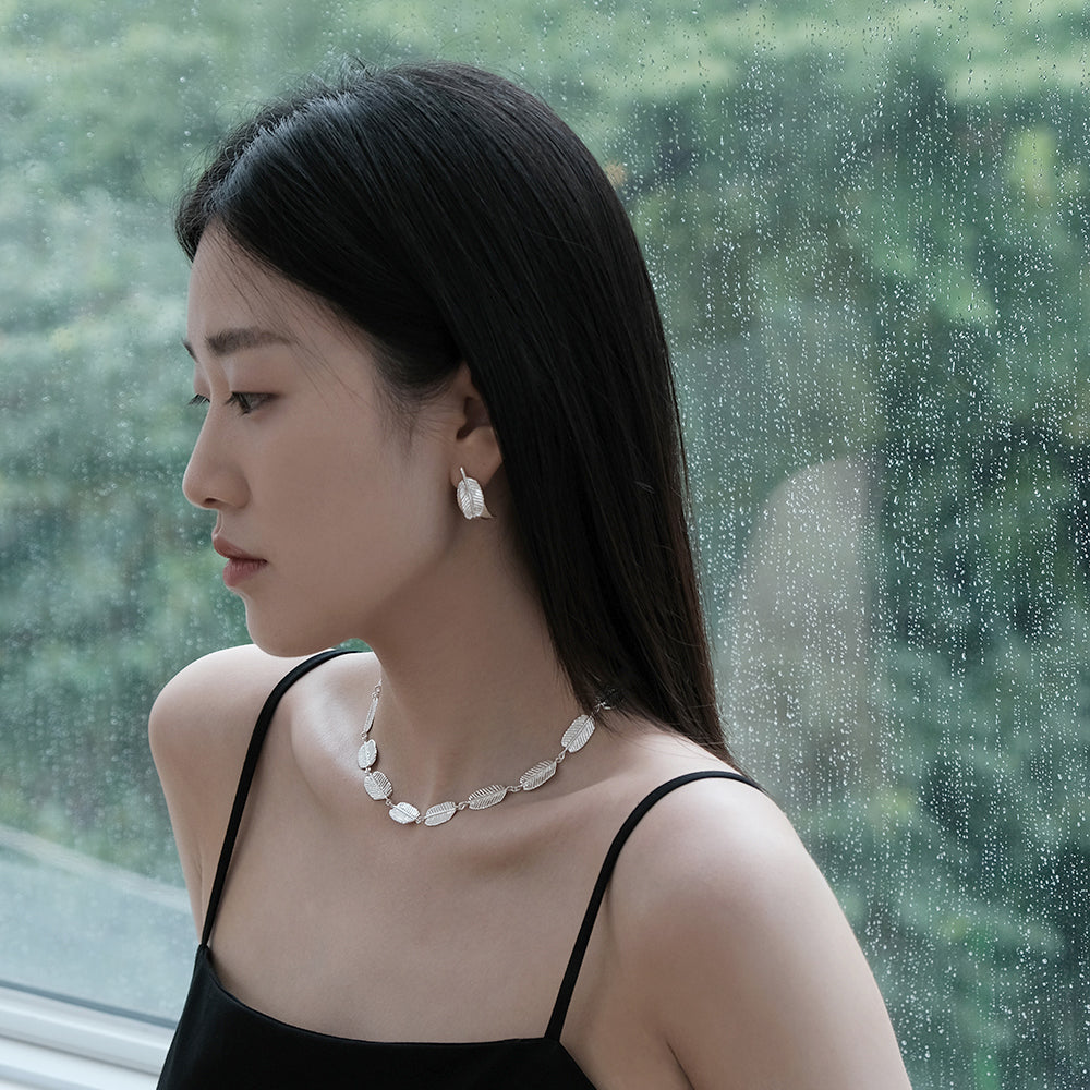 an Asian woman wearing Chipe chirit handmade 2 Acacia leaf earrings and necklace