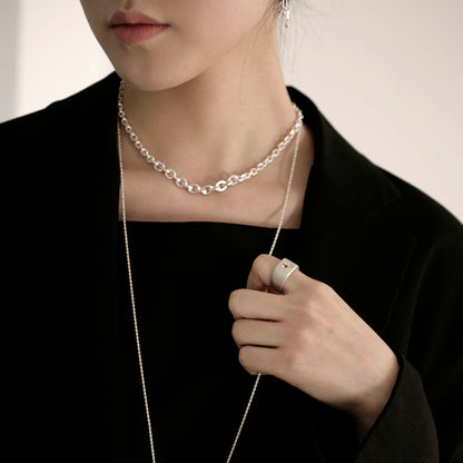 A woman wearing black clothes and chipe Chirit simple handmade silver connect chain necklace with a long silver necklace and a silver ring with a cross