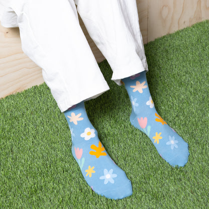 Woman wearing luxurious sky blue ankle socks with fun cute multi color floral patterns with white pants