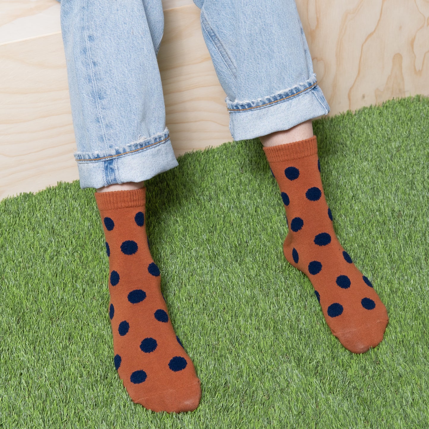 Detailed view of brown socks with navy polka dots