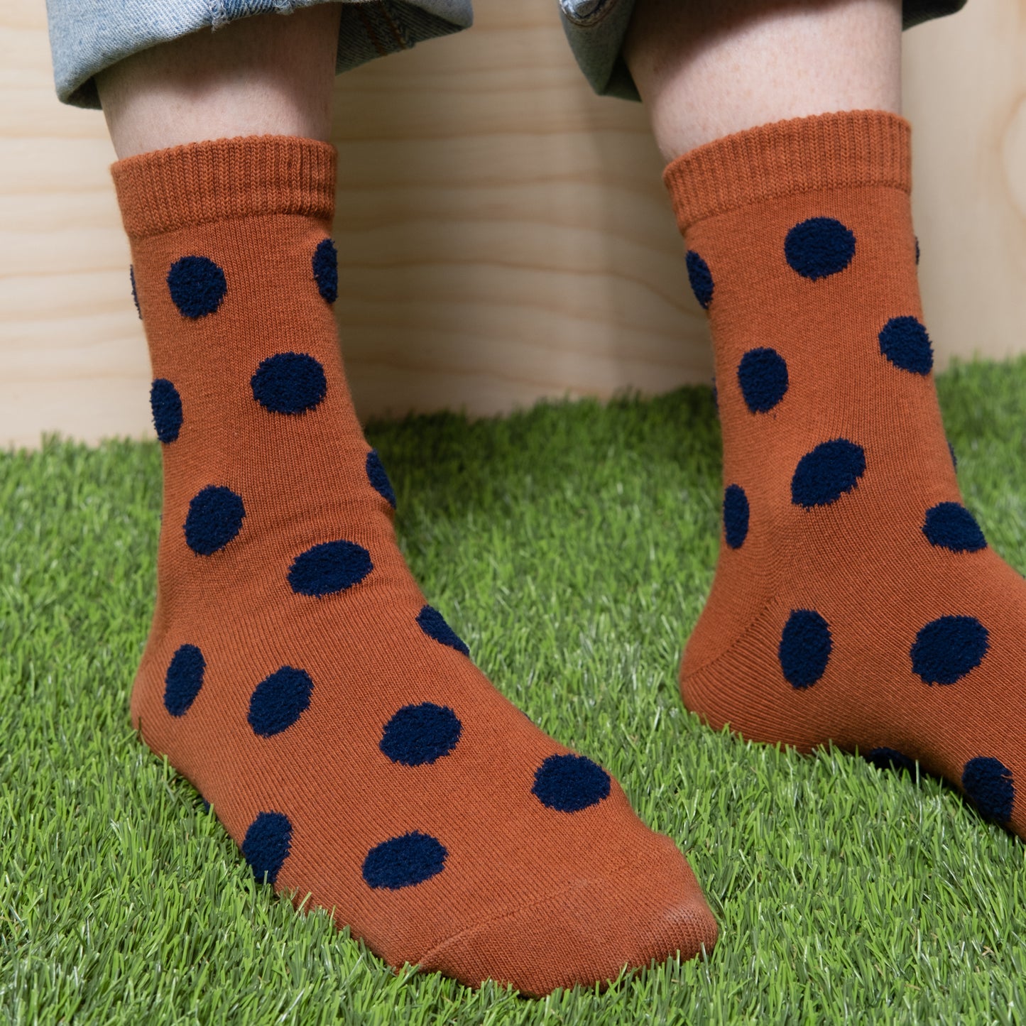 Detailed view of brown socks with navy polka dots