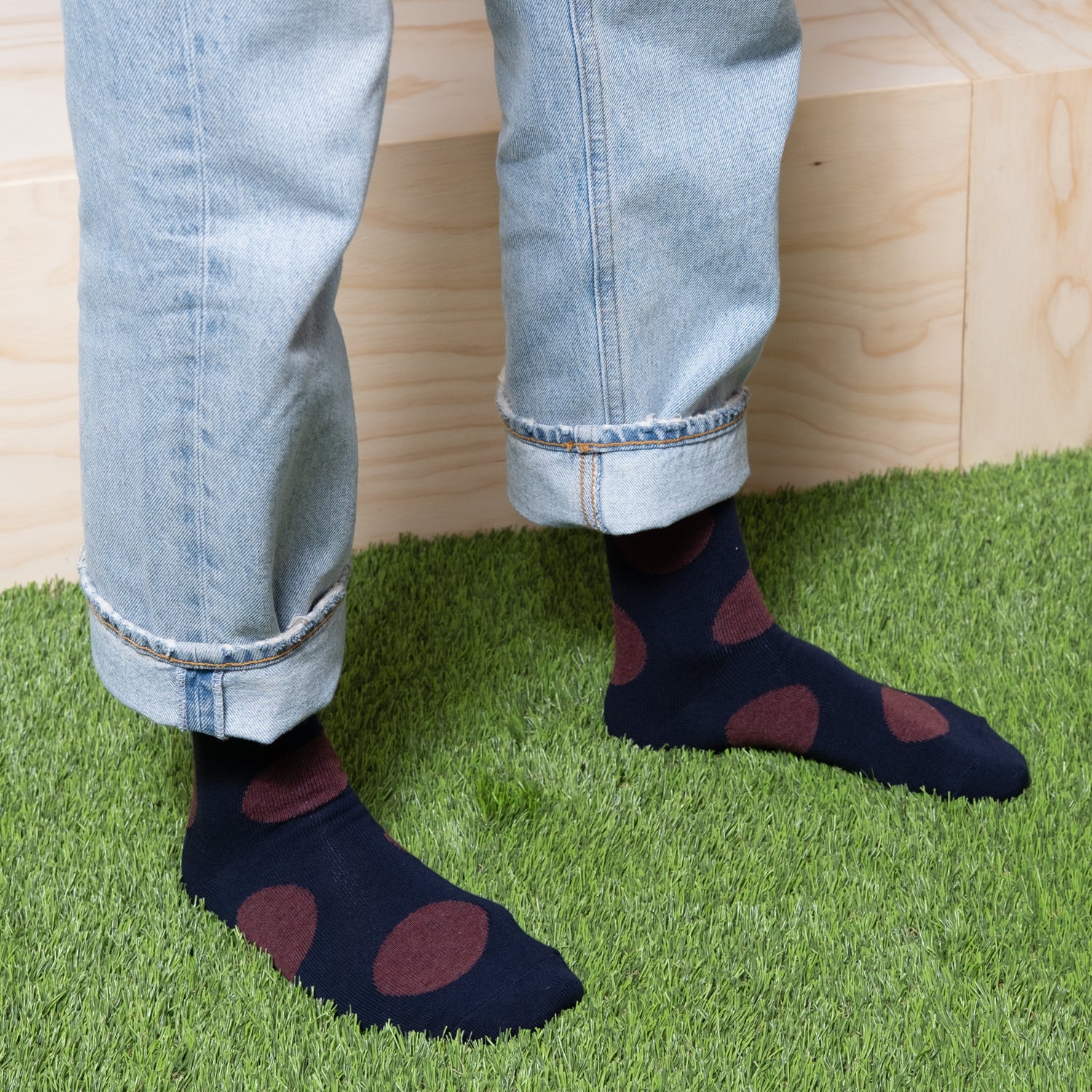 Bold red polka dots on navy socks worn by a woman