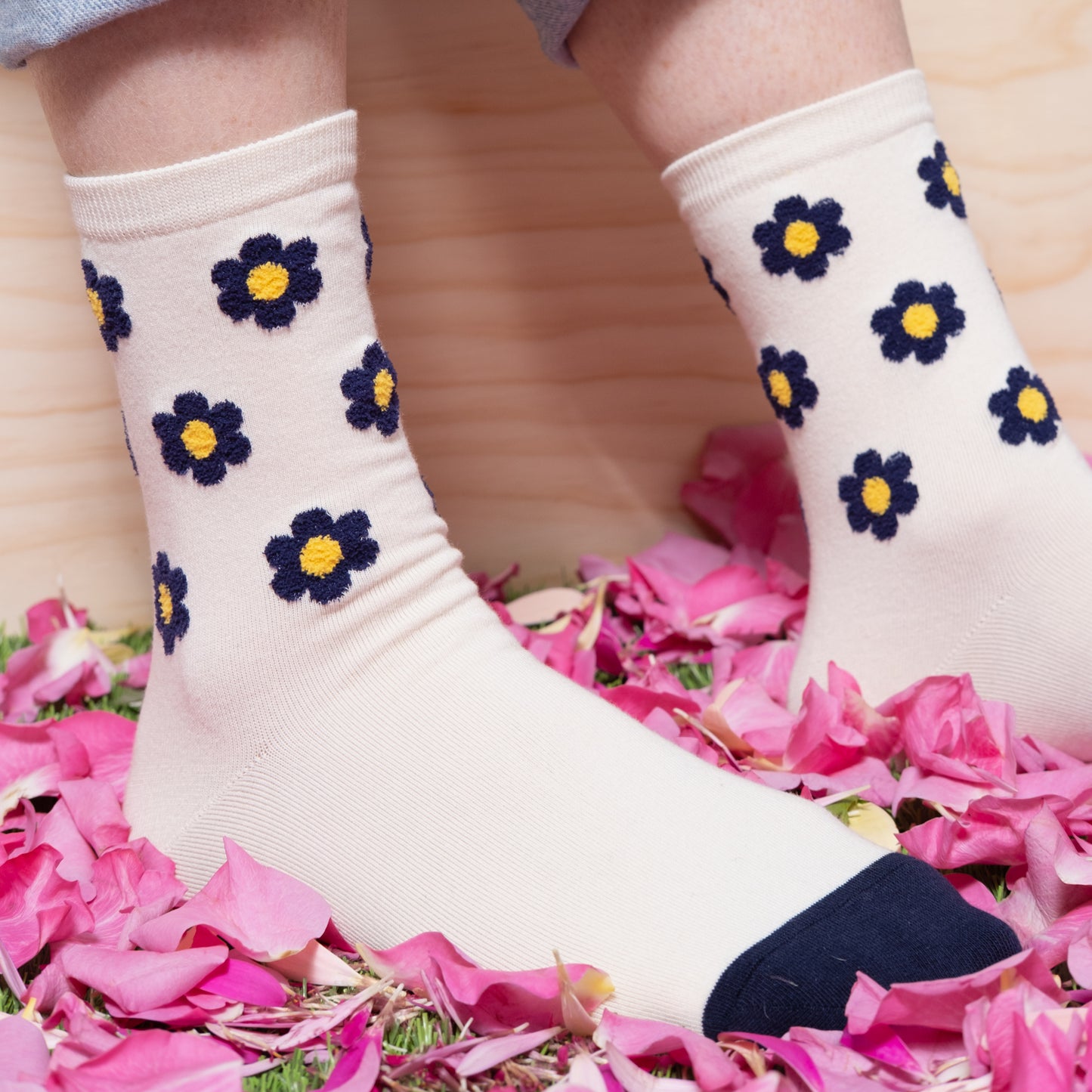 Detail view of woman wearing luxurious white ankle sock with navy floral dots pattern