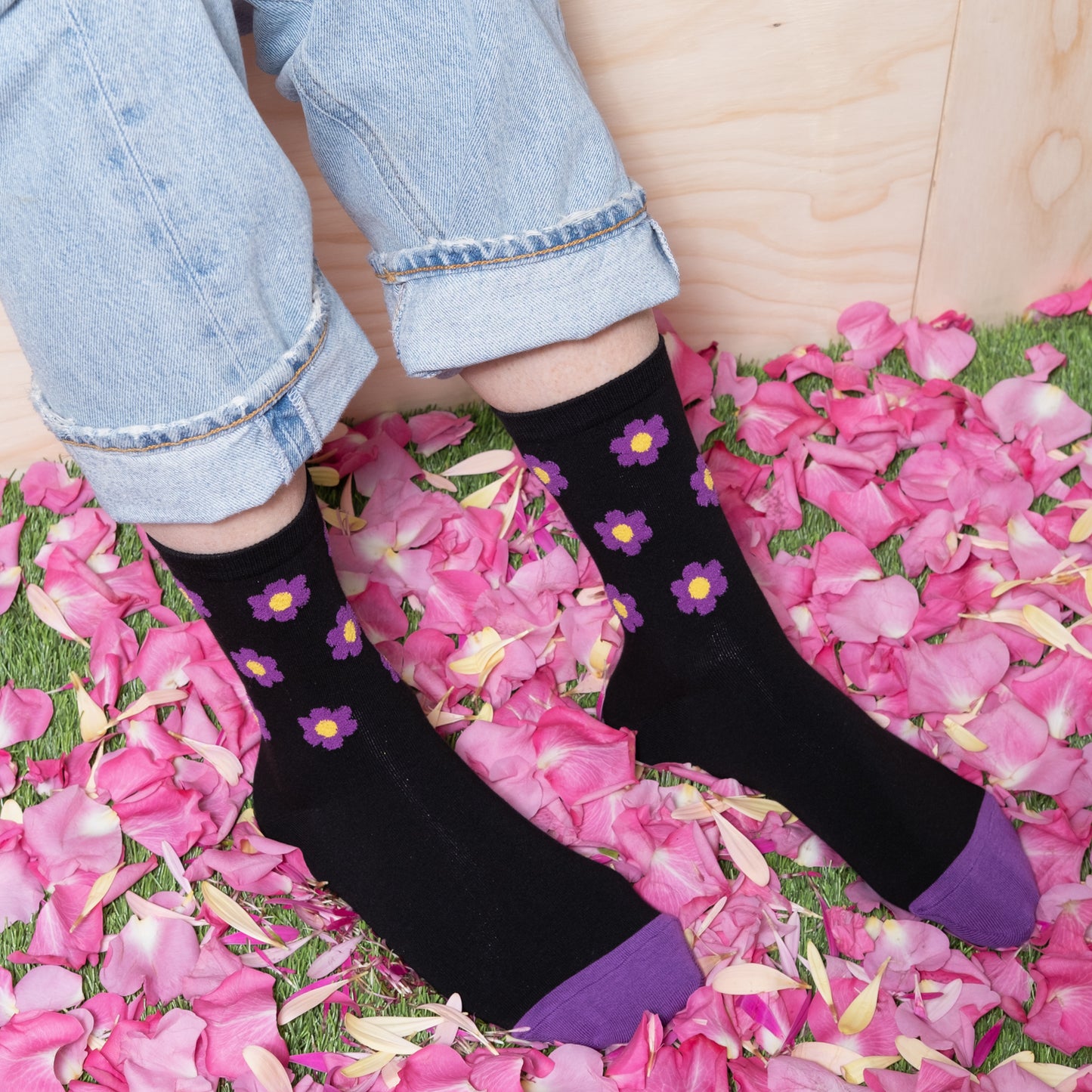 woman wearing luxurious black ankle sock with purple floral dots pattern with blue jeans