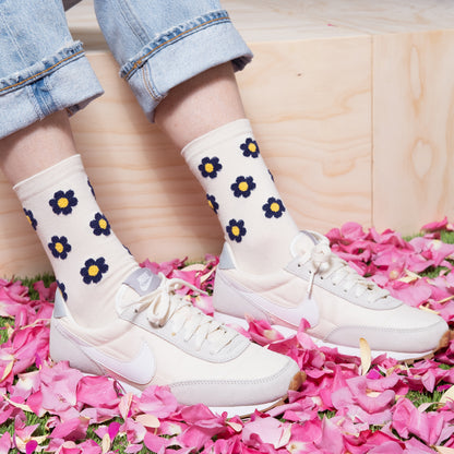 woman wearing luxurious white ankle sock with navy floral dots pattern with blue jeans and with white nike sneakers